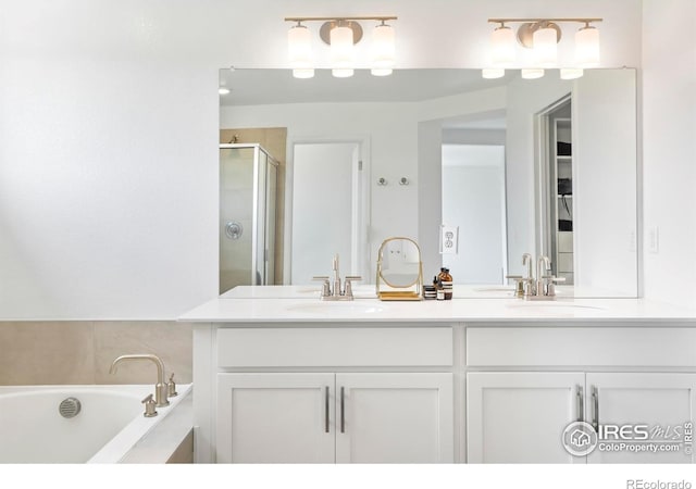 bathroom with a shower stall, double vanity, and a garden tub