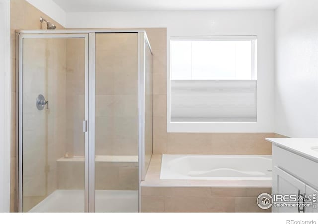 full bathroom featuring a stall shower, a garden tub, and vanity
