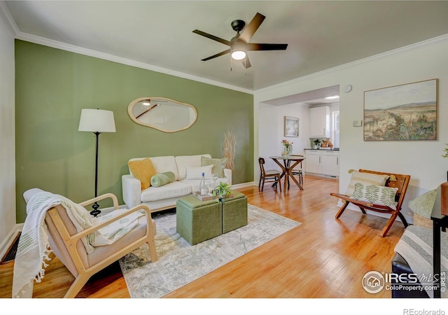 1235 Leyden St, Denver, CO 80220 - living room with light wood-style floors, crown molding, ceiling fan, and baseboards