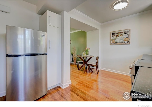 1235 Leyden St, Denver, CO 80220 - kitchen with stainless steel appliances, ornamental molding, light wood-style floors, white cabinetry, and baseboards