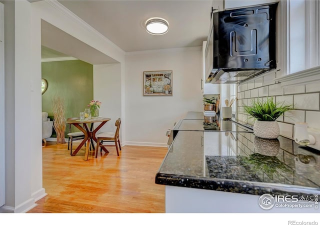 1235 Leyden St, Denver, CO 80220 - kitchen featuring ornamental molding, light wood-style flooring, black microwave, baseboards, and white cabinets
