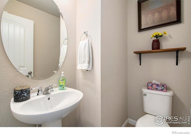 half bathroom featuring a sink and toilet
