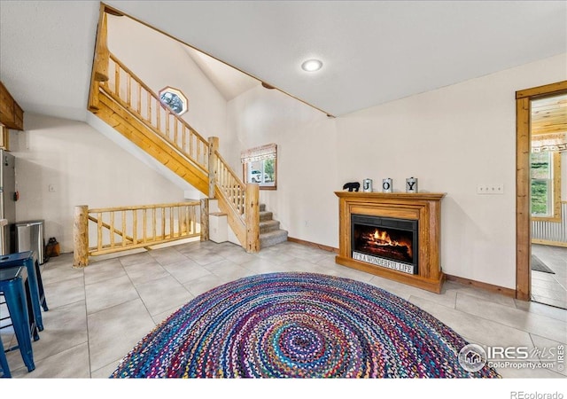 457 Spruce Mountain Dr, Drake, CO 80515 - living room with stairs, tile patterned flooring, lofted ceiling, a lit fireplace, and baseboards