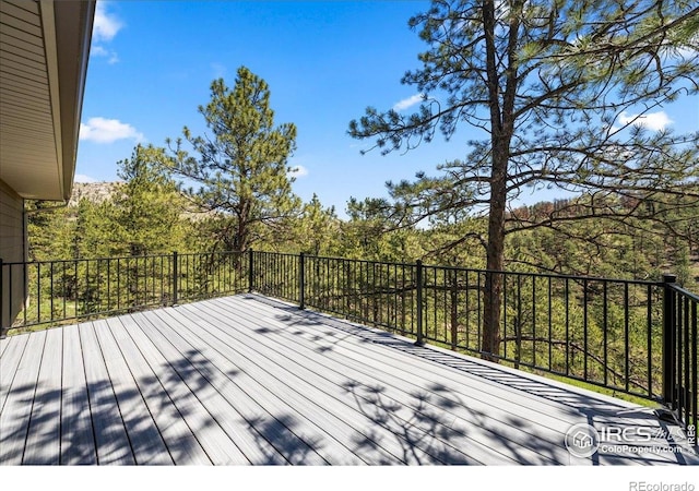 457 Spruce Mountain Dr, Drake, CO 80515 - wooden terrace featuring a wooded view