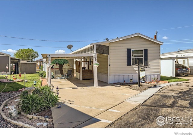rear view of house with driveway and an attached carport