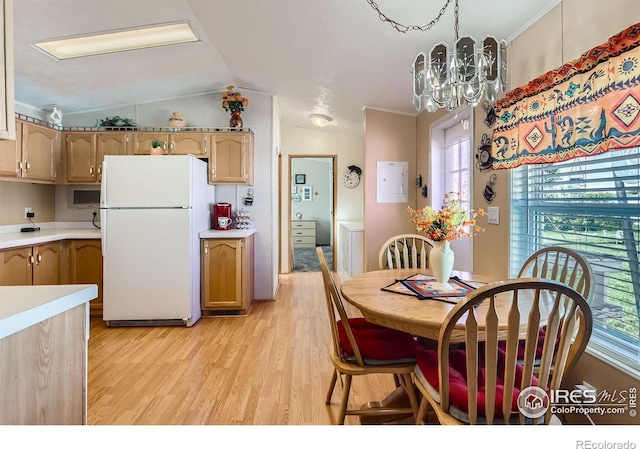 dining room with light wood finished floors, vaulted ceiling, a chandelier, and ornamental molding