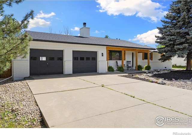 view of front facade featuring an attached garage, concrete driveway, brick siding, and covered porch
