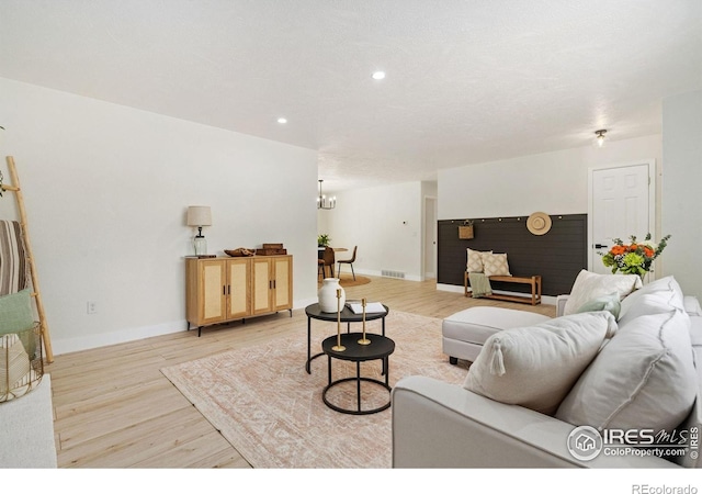living room featuring light wood finished floors, recessed lighting, baseboards, and a chandelier