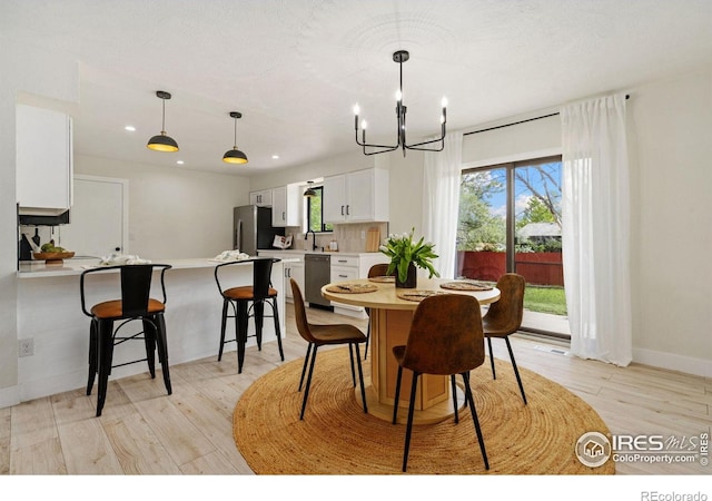 dining room featuring a chandelier, light wood-type flooring, baseboards, and recessed lighting