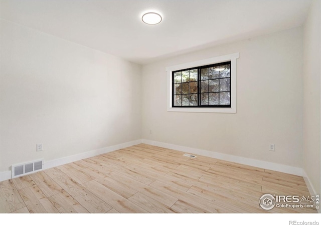 unfurnished room with wood finished floors and baseboards