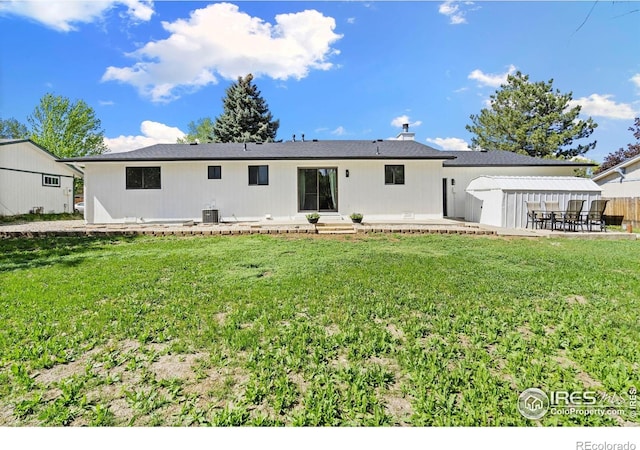 rear view of property featuring a patio area, a lawn, and central air condition unit