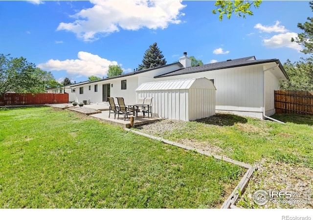 rear view of property with a patio, a shed, an outdoor structure, and a chimney