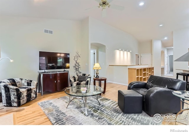 living room with arched walkways, wood finished floors, a ceiling fan, and recessed lighting