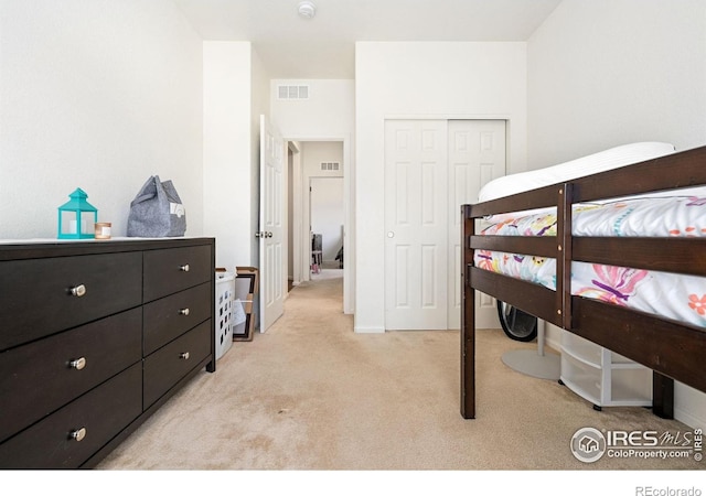 bedroom featuring light colored carpet and a closet