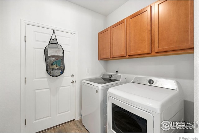 laundry area with washer and clothes dryer, cabinet space, and light wood-type flooring