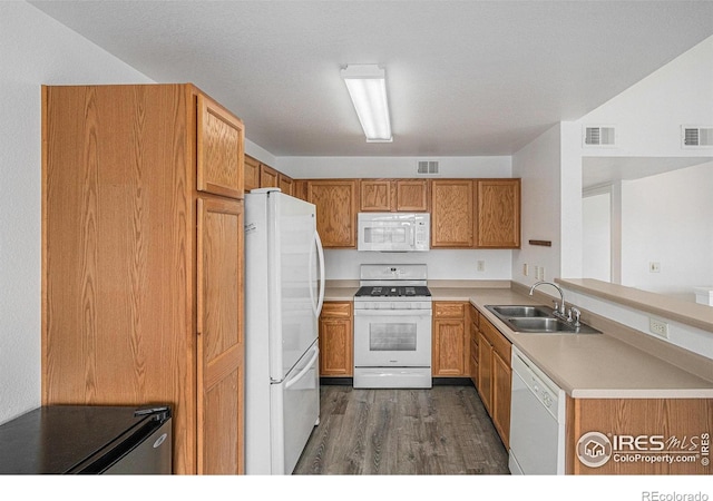 3002 W Elizabeth St Unit G, Fort Collins, CO 80521 - kitchen with white appliances, a sink, dark wood finished floors, light countertops, and a peninsula