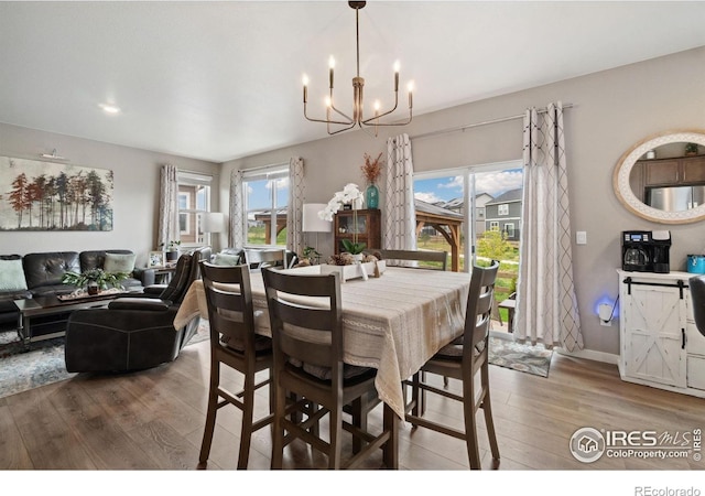 dining area featuring a chandelier, wood finished floors, and baseboards