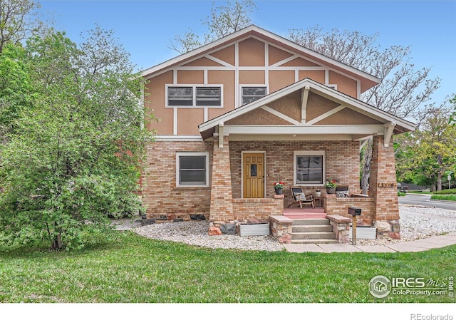 3116 47th St, Boulder, CO 80301 - tudor-style house with a front yard, covered porch, stucco siding, and brick siding