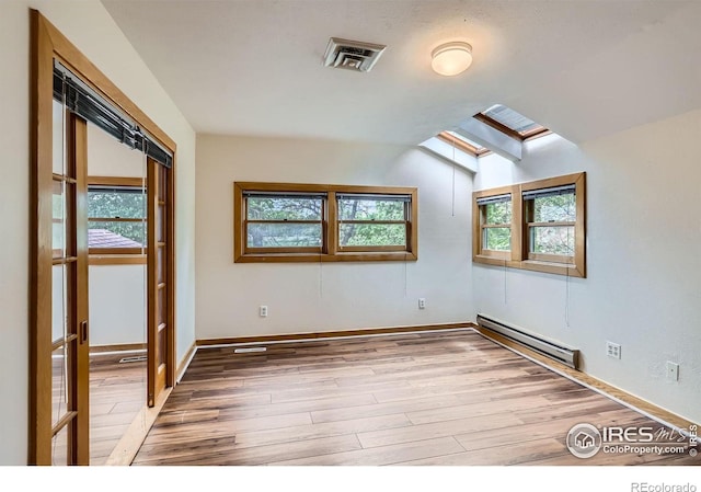 3116 47th St, Boulder, CO 80301 - unfurnished room featuring a baseboard radiator, a skylight, light wood-style floors, lofted ceiling, and baseboards