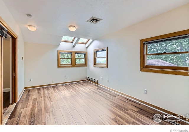 3116 47th St, Boulder, CO 80301 - unfurnished bedroom featuring a skylight, baseboard heating, light wood-type flooring, vaulted ceiling, and baseboards