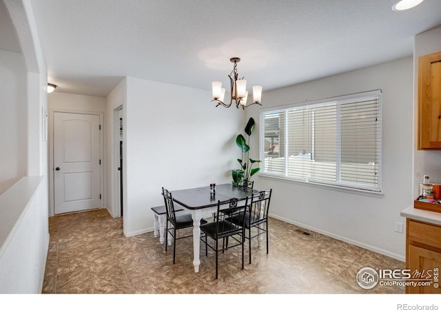 7505 Little Fox Ln, Wellington, CO 80549 - dining room featuring a chandelier, baseboards, and arched walkways