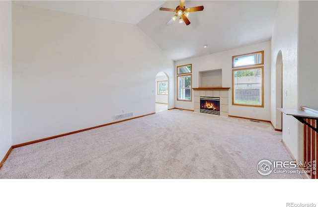 374 Blue Azurite Ave, Loveland, CO 80537 - unfurnished living room featuring arched walkways, light carpet, a ceiling fan, baseboards, and vaulted ceiling