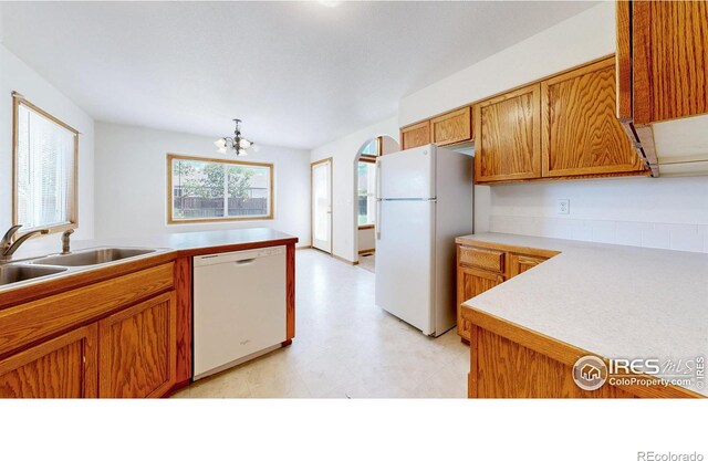 374 Blue Azurite Ave, Loveland, CO 80537 - kitchen with white appliances, a sink, brown cabinets, light floors, and light countertops