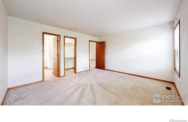 374 Blue Azurite Ave, Loveland, CO 80537 - unfurnished bedroom with carpet flooring, baseboards, a walk in closet, and multiple windows