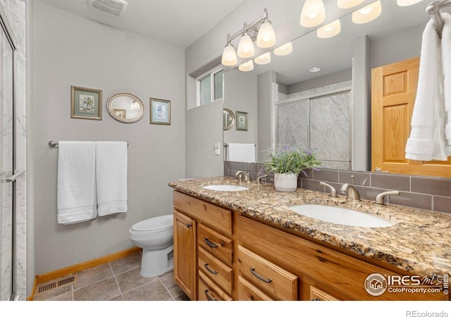 1918 Lily Dr, Loveland, CO 80537 - bathroom featuring a stall shower, toilet, baseboards, double vanity, and tile patterned floors