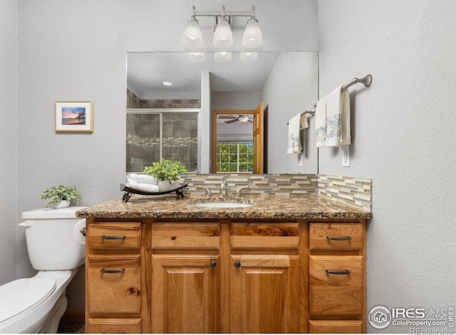 1918 Lily Dr, Loveland, CO 80537 - full bath featuring toilet, decorative backsplash, a stall shower, ceiling fan, and vanity