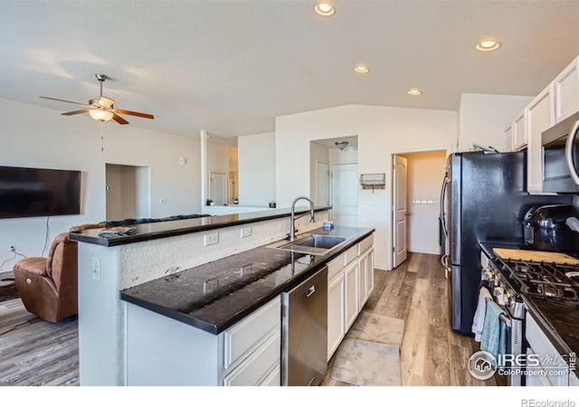 4134 Cypress Ridge Ln, Wellington, CO 80549 - kitchen with a sink, an island with sink, a ceiling fan, white cabinetry, and stainless steel appliances