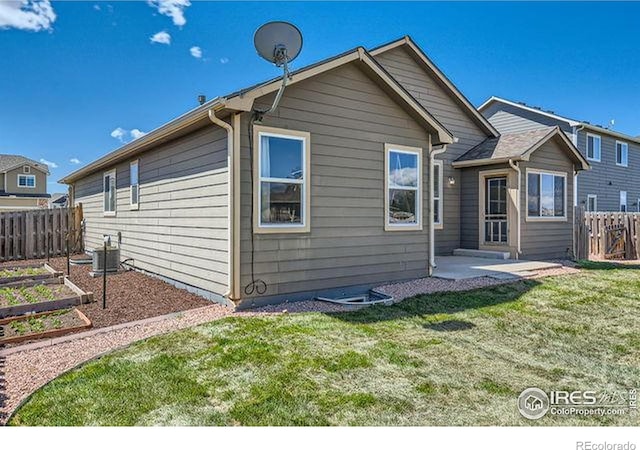 4134 Cypress Ridge Ln, Wellington, CO 80549 - back of house featuring a vegetable garden, central air condition unit, and a patio area