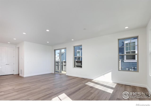 197 Liberty St, Erie, CO 80516 - unfurnished living room with light wood-style flooring, recessed lighting, and baseboards