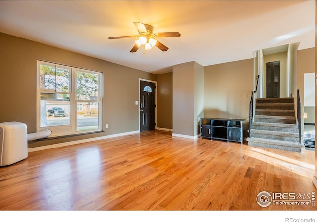110 Lucerne Dr, Lafayette, CO 80026 - unfurnished living room featuring ceiling fan, stairway, wood finished floors, and baseboards