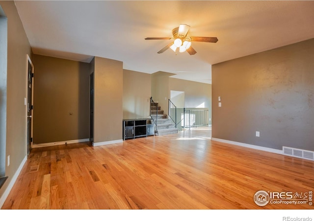 110 Lucerne Dr, Lafayette, CO 80026 - unfurnished living room featuring a ceiling fan, light wood-style floors, stairs, and baseboards