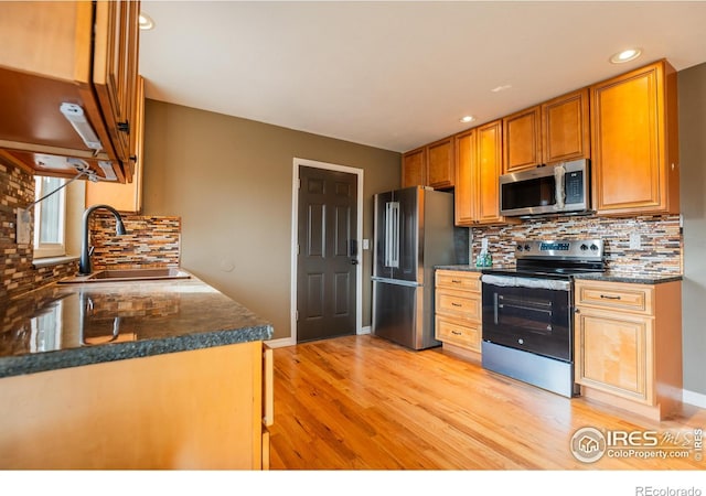 110 Lucerne Dr, Lafayette, CO 80026 - kitchen with stainless steel appliances, a sink, light wood finished floors, backsplash, and recessed lighting