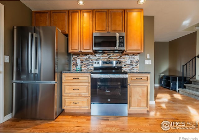 110 Lucerne Dr, Lafayette, CO 80026 - kitchen featuring appliances with stainless steel finishes, light wood-type flooring, tasteful backsplash, recessed lighting, and brown cabinets