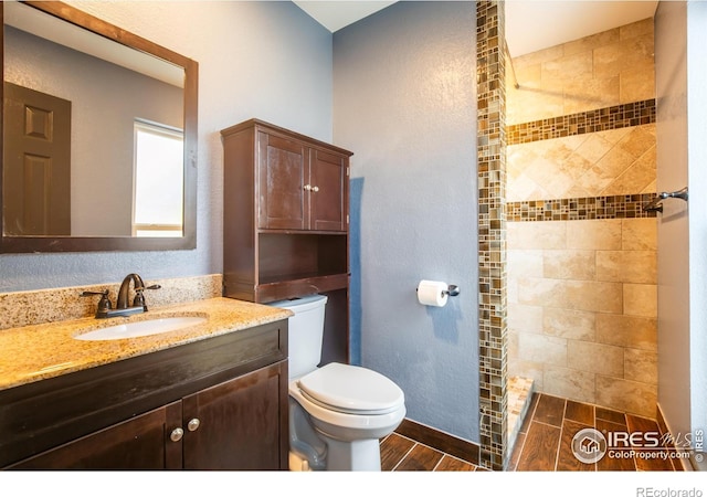 110 Lucerne Dr, Lafayette, CO 80026 - full bathroom with toilet, tiled shower, vanity, and a textured wall
