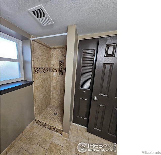 110 Lucerne Dr, Lafayette, CO 80026 - full bath featuring baseboards, a tile shower, and a textured ceiling