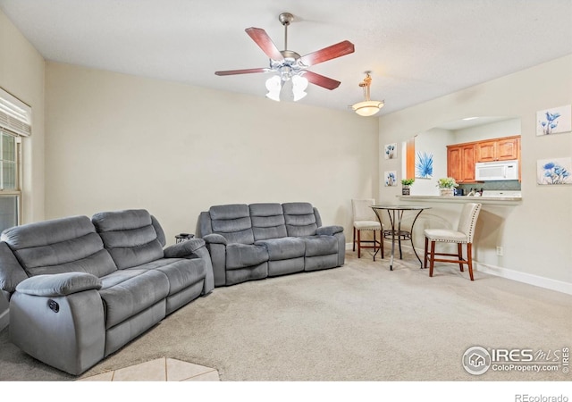 carpeted living area with a ceiling fan, arched walkways, and baseboards