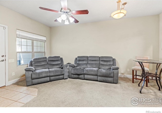 living area with carpet floors, ceiling fan, and baseboards
