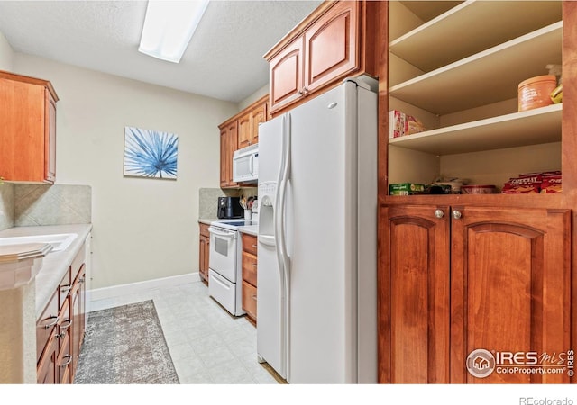 kitchen featuring white appliances, light countertops, baseboards, and tasteful backsplash