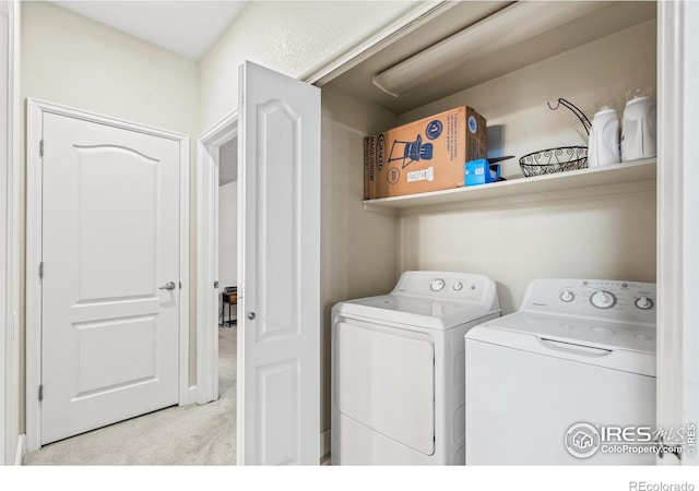 clothes washing area featuring washer and dryer and carpet flooring