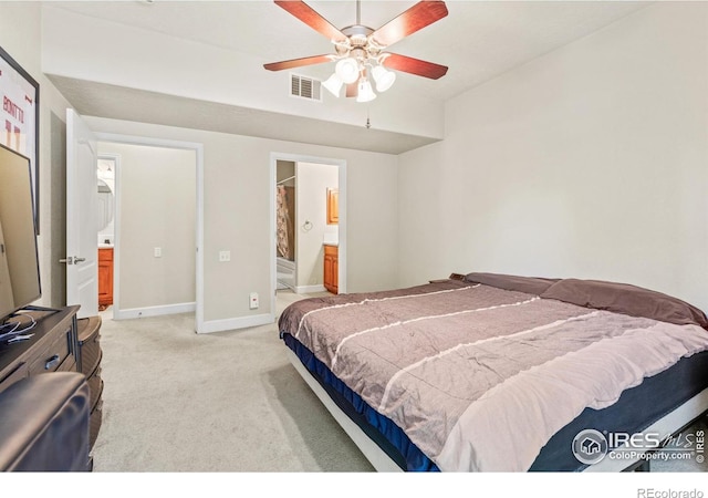 bedroom featuring light colored carpet, baseboards, connected bathroom, and ceiling fan