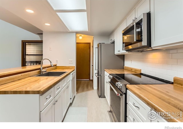 2962 Shadow Creek Dr Unit 306, Boulder, CO 80303 - kitchen with butcher block countertops, stainless steel appliances, a sink, white cabinetry, and recessed lighting
