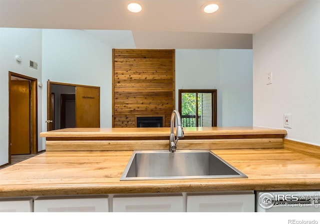 2962 Shadow Creek Dr Unit 306, Boulder, CO 80303 - kitchen featuring a sink, white cabinets, a fireplace, and recessed lighting