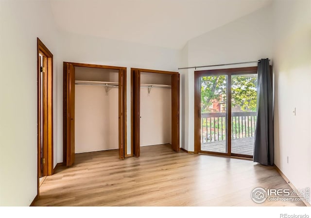 2962 Shadow Creek Dr Unit 306, Boulder, CO 80303 - unfurnished bedroom featuring access to exterior, light wood-type flooring, two closets, and lofted ceiling