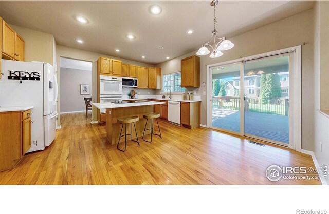 3221 Mesa Verde St, Fort Collins, CO 80525 - kitchen with white appliances, a sink, a kitchen island, a breakfast bar, and light countertops