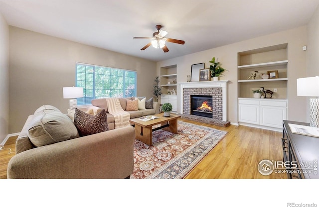 3221 Mesa Verde St, Fort Collins, CO 80525 - living room featuring ceiling fan, light wood finished floors, a fireplace, and built in shelves