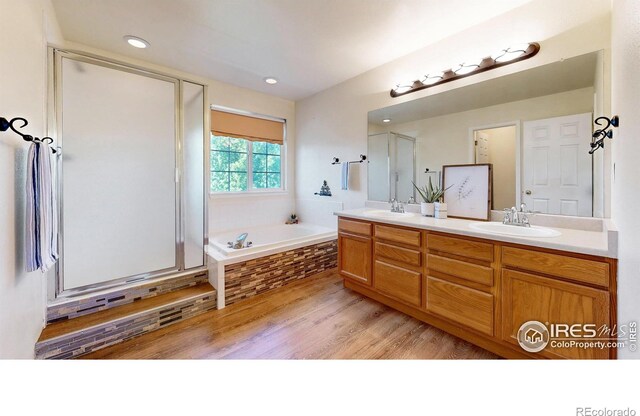 3221 Mesa Verde St, Fort Collins, CO 80525 - bathroom featuring wood finished floors, a bath, double vanity, a stall shower, and recessed lighting